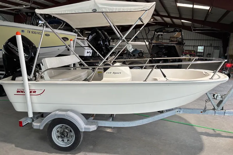 Slide: The Image of 2017 Boston Whaler 110 Sport boat on trailer in indoor storage facility. - 0