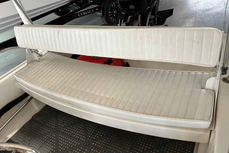 Slide: The Image of 2017 Boston Whaler 110 Sport boat interior with white cushioned seating. - 3