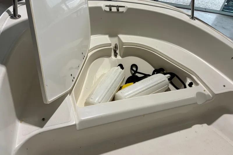 Slide: The Image of 2017 Boston Whaler 110 Sport boat storage compartment with fenders and ropes. - 7
