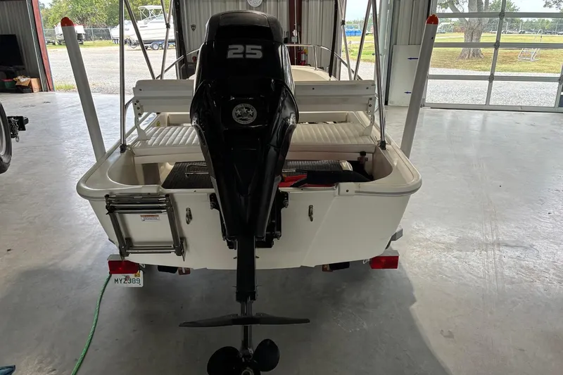 Slide: The Image of 2017 Boston Whaler 110 Sport boat with 25 HP outboard motor in a garage. - 8
