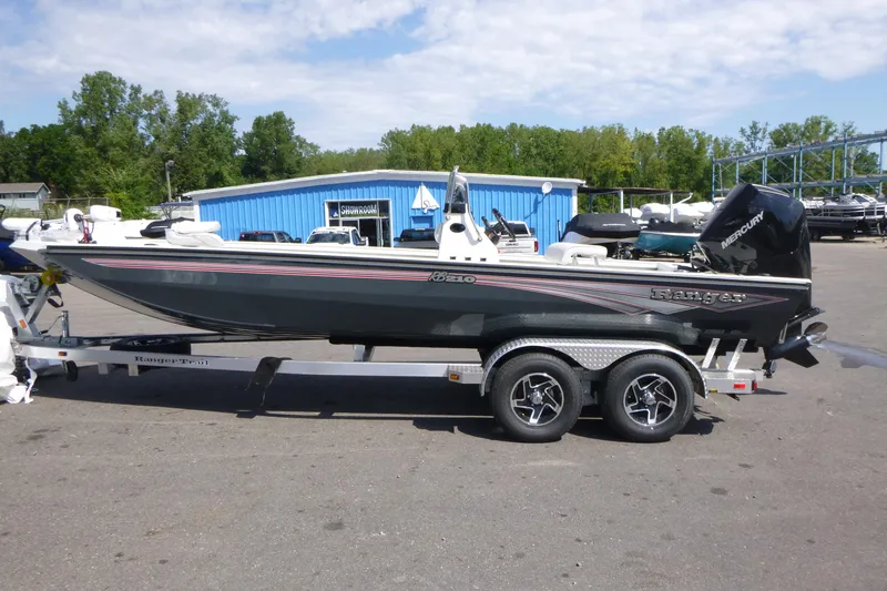 Slide: The Image of 2025 Ranger RB210 boat on trailer, parked outside showroom under clear sky. - 3