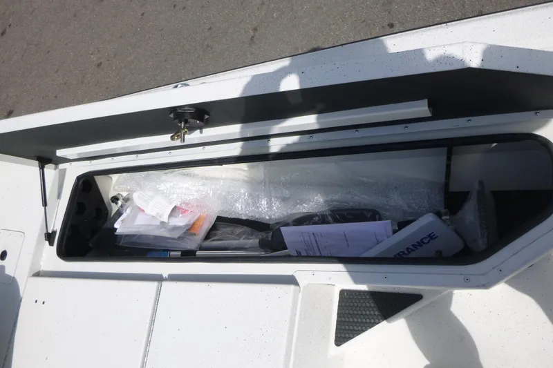 Slide: The Image of Storage compartment of 2025 Ranger RB210 boat with various items inside. - 8