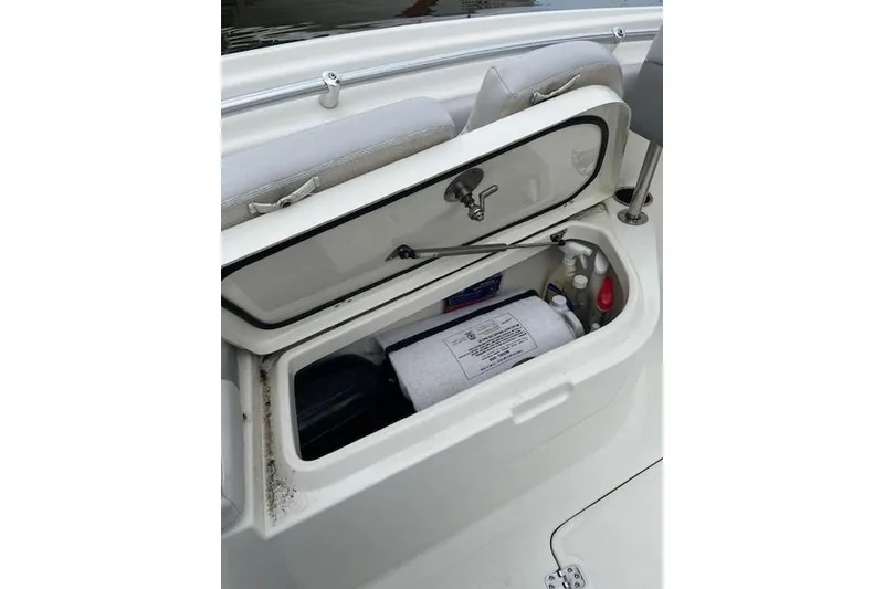Slide: The Image of Open storage compartment on 2021 Mako 214 CC boat, showing interior contents and design. - 10