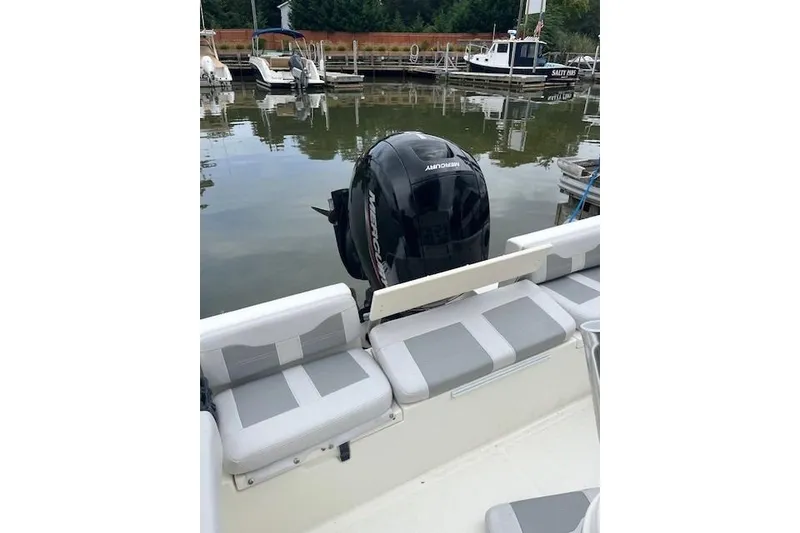 Slide: The Image of 2021 Mako 214 CC boat with Mercury engine, docked at a marina. - 14