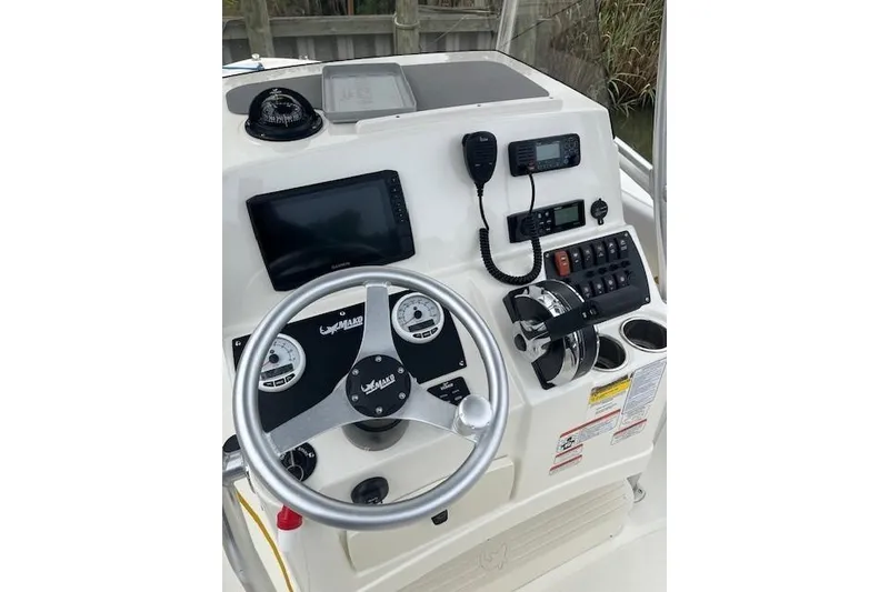 Slide: The Image of 2021 Mako 214 CC boat console with steering wheel, gauges, and navigation equipment. - 15