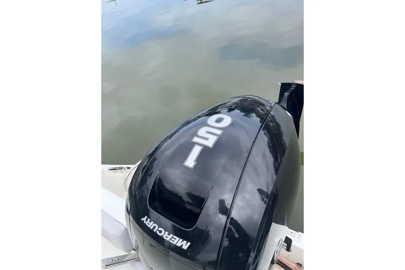 Slide: The Image of Mercury 150 outboard motor on 2021 Mako 214 CC boat by the water. - 16