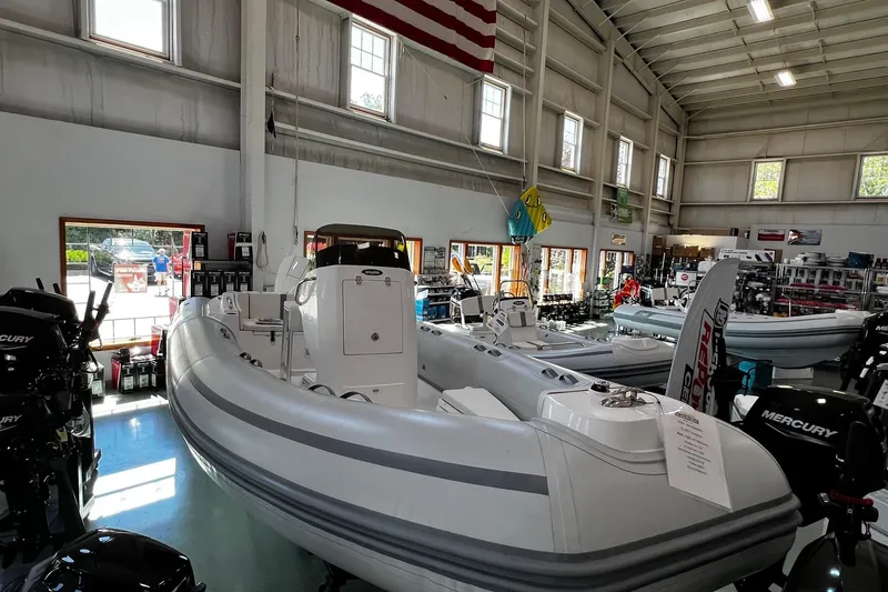 The Image of 2024 AB Inflatables Oceanus 21 VST boat displayed in a showroom with Mercury engines. - 0