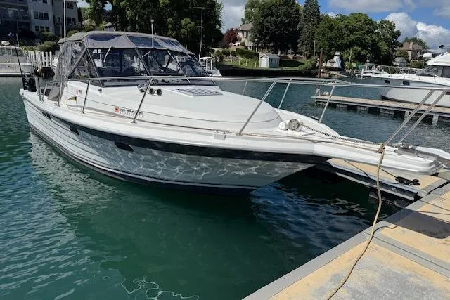 Slide: The Image of 1988 Penn Yan Predator 288 boat docked in a marina, surrounded by calm water. - 3