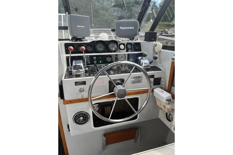 Slide: The Image of 1988 Penn Yan Predator 288 boat dashboard with steering wheel and Raymarine equipment. - 33