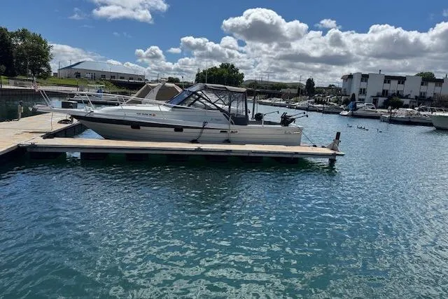 Slide: The Image of 1988 Penn Yan Predator 288 boat docked in a marina under a partly cloudy sky. - 5