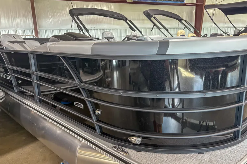 The Image of 2025 Trifecta 22 RF CS pontoon boat in showroom, featuring sleek black exterior design. - 1