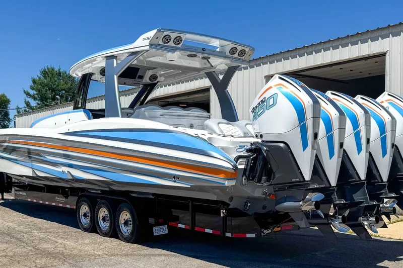 Slide: The Image of 2023 MTI 50 V boat with multiple engines on a trailer, parked outside a building. - 11