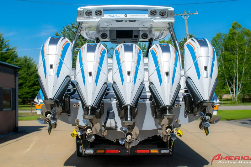 Slide: The Image of Five powerful outboard motors on a 2023 MTI 50 V boat, parked outdoors. - 7