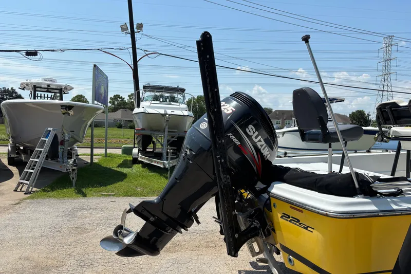 Slide: The Image of Yellow Epic 22 boat with Suzuki outboard motor, parked among other boats, 2014 model. - 3