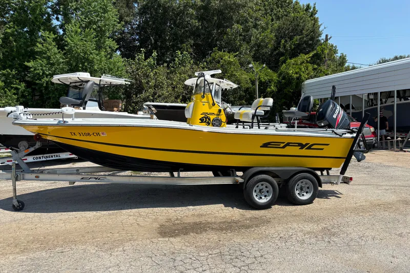 Slide: The Image of Yellow 2014 Epic 22 boat on trailer, parked outdoors with trees in background. - 4