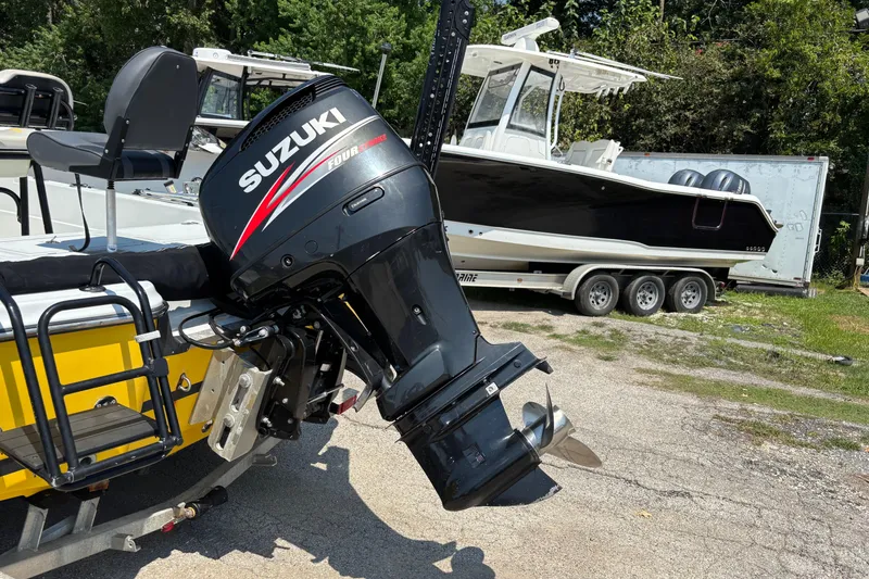 Slide: The Image of Boat with Suzuki outboard motor, Epic 22 model, 2014, parked on a trailer. - 5