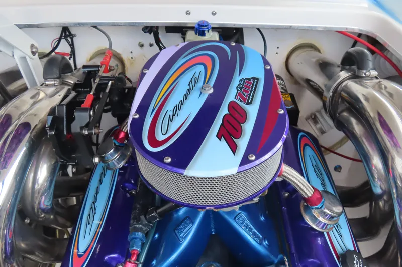 Slide: The Image of Engine of a 2004 Cigarette 38 Top Gun TS boat, featuring vibrant colors and branding. - 16