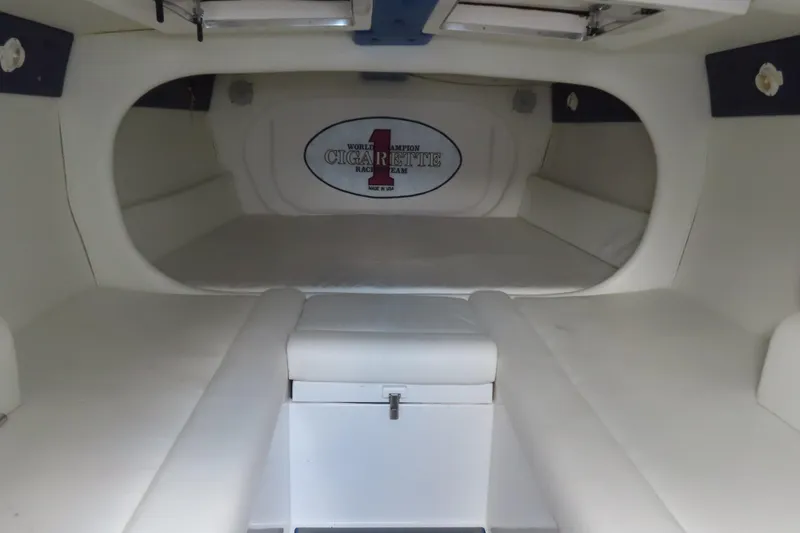 Slide: The Image of Interior of 2004 Cigarette 38 Top Gun TS boat, featuring white seating and storage. - 24