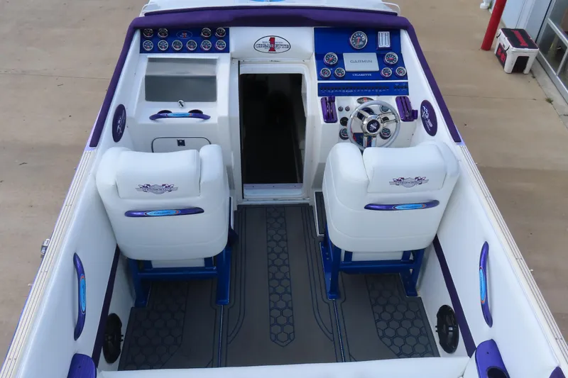 Slide: The Image of 2004 Cigarette 38 Top Gun TS boat interior with white and blue seating, dashboard, and controls. - 6