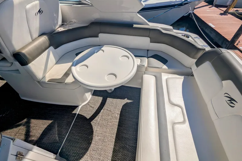 Slide: The Image of 2013 Monterey 280 Sport Yacht interior with cushioned seating and round table. - 11