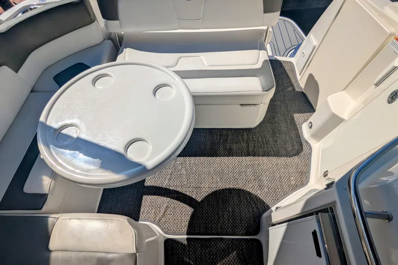 Slide: The Image of 2013 Monterey 280 Sport Yacht interior with round table and cushioned seating. - 13