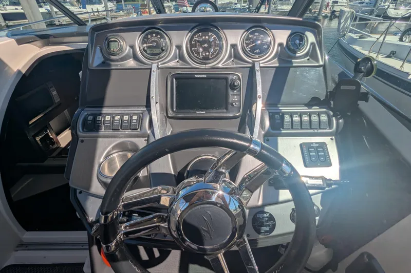 Slide: The Image of Dashboard of a 2013 Monterey 280 Sport Yacht with steering wheel and navigation controls. - 18