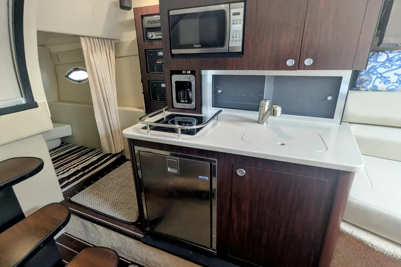 Slide: The Image of Compact kitchen area in 2013 Monterey 280 Sport Yacht with microwave, sink, and stove. - 26