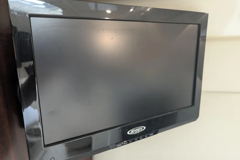 Slide: The Image of Jensen TV screen inside 2013 Monterey 280 Sport Yacht, mounted on a wooden panel. - 31