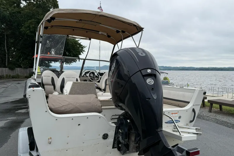 Slide: The Image of 2014 Crestliner 1850 Sportfish boat with outboard motor by a lake. - 3