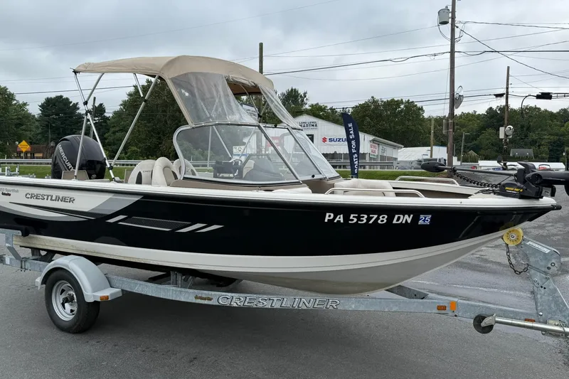 Slide: The Image of 2014 Crestliner 1850 Sportfish boat on trailer, parked outdoors, with canopy and motor. - 5