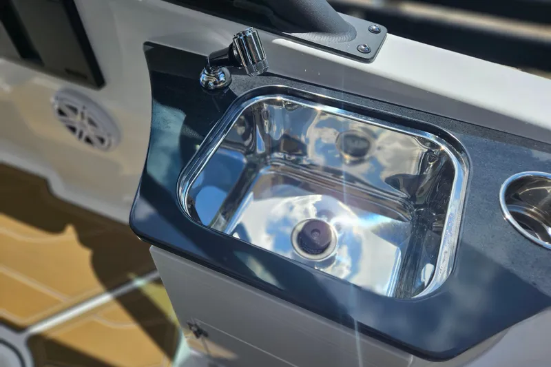 Slide: The Image of Stainless steel sink on 2026 Monterey Elite 25 OB boat, reflecting sky and clouds. - 16