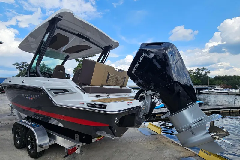 Slide: The Image of 2026 Monterey Elite 25 OB boat with Mercury outboard motor at a marina. - 2