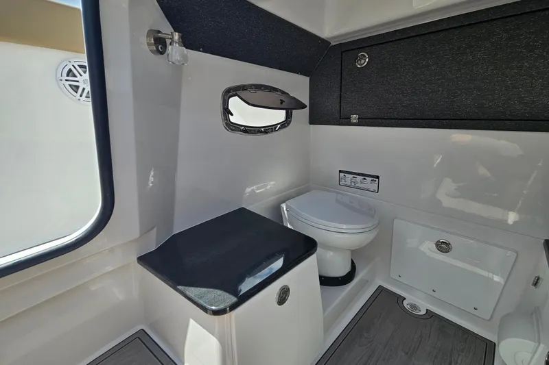 Slide: The Image of Interior of 2026 Monterey Elite 25 OB boat featuring a compact bathroom with toilet. - 20