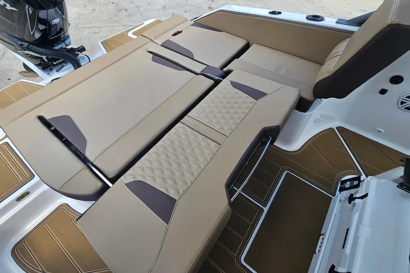 Slide: The Image of 2026 Monterey Elite 25 OB boat interior with tan cushioned seating and modern design. - 27