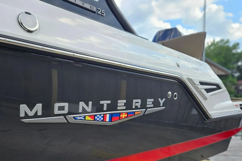 Slide: The Image of 2026 Monterey Elite 25 OB boat, sleek design with nautical flags, close-up view. - 35