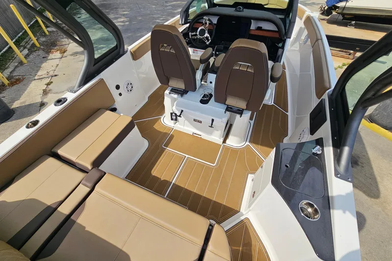 Slide: The Image of 2026 Monterey Elite 25 OB boat interior with brown seating and modern dashboard. - 7