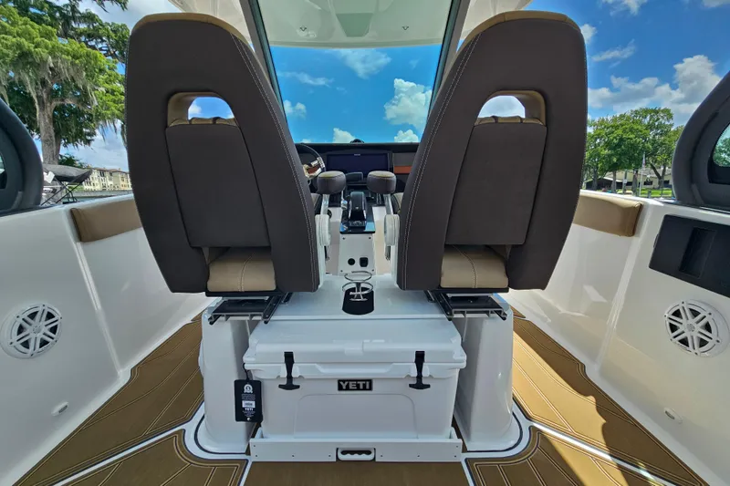 Slide: The Image of 2026 Monterey Elite 25 OB boat interior with dual seats and Yeti cooler. - 9