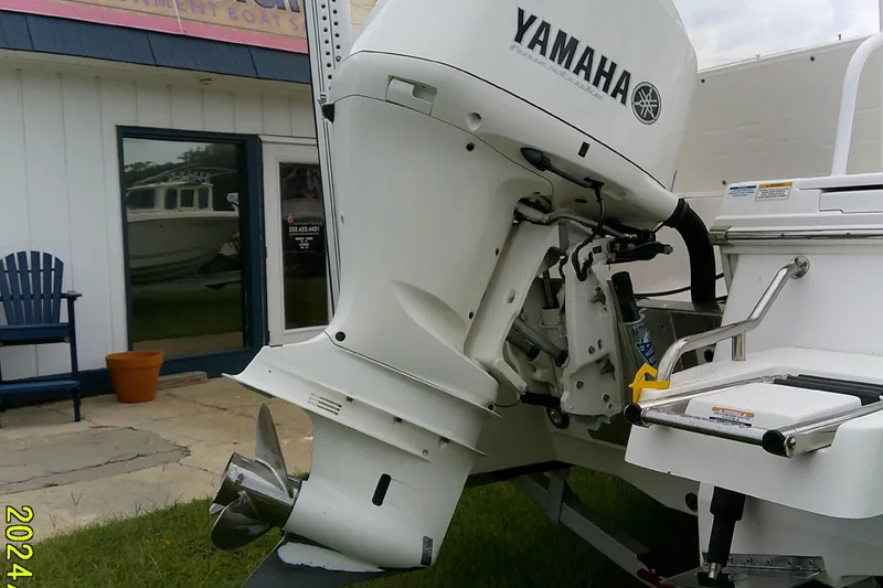 Slide: The Image of 2021 Robalo 246 Cayman with Yamaha outboard motor, displayed outside a boat dealership. - 10