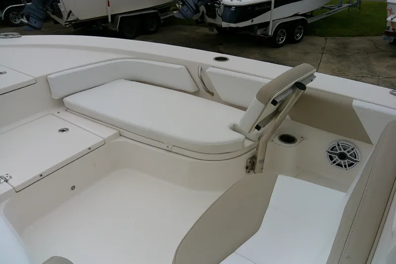 Slide: The Image of 2021 Robalo 246 Cayman boat interior with white seating and storage compartments. - 14
