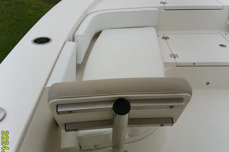 Slide: The Image of 2021 Robalo 246 Cayman boat interior with white seating and storage compartments. - 15