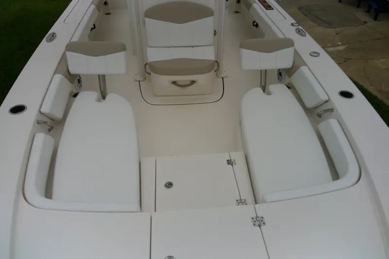 Slide: The Image of 2021 Robalo 246 Cayman boat interior with white seating and storage compartments. - 17