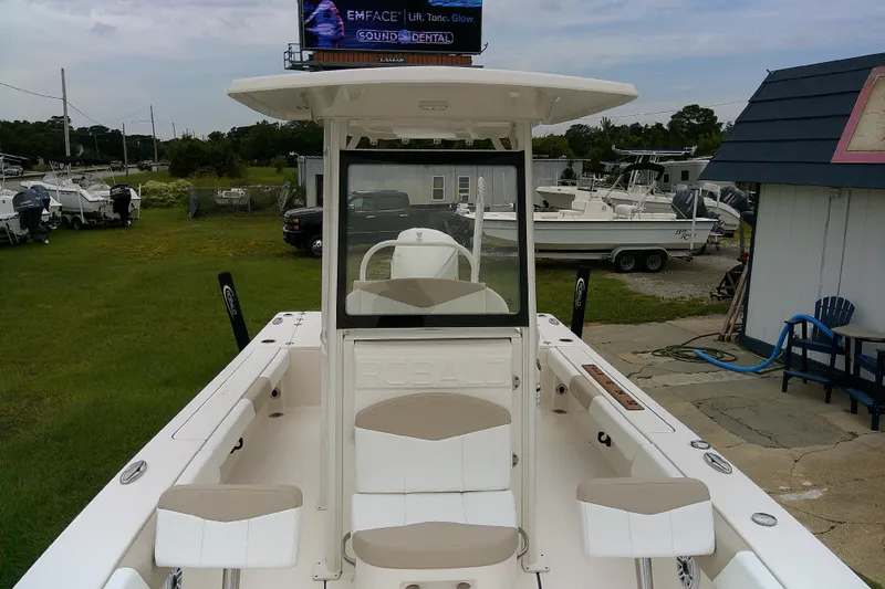 Slide: The Image of 2021 Robalo 246 Cayman boat, white interior, docked outdoors with other boats nearby. - 18