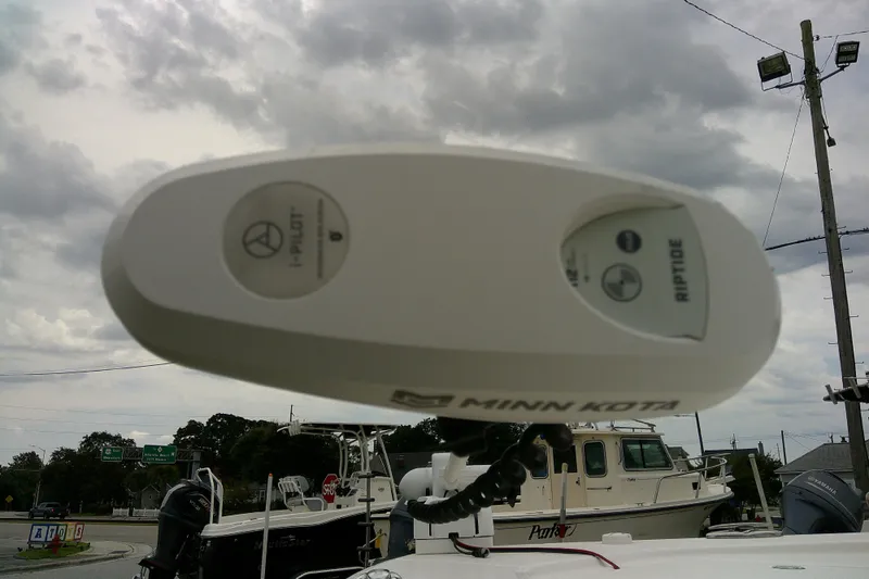 Slide: The Image of Minn Kota Riptide motor on 2021 Robalo 246 Cayman boat under cloudy sky. - 2