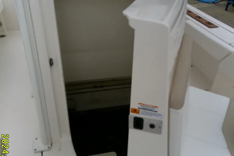 Slide: The Image of 2021 Robalo 246 Cayman boat interior detail with white seating and storage area. - 21