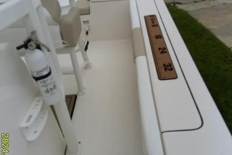 Slide: The Image of 2021 Robalo 246 Cayman boat interior with seating, fire extinguisher, and measuring ruler. - 23
