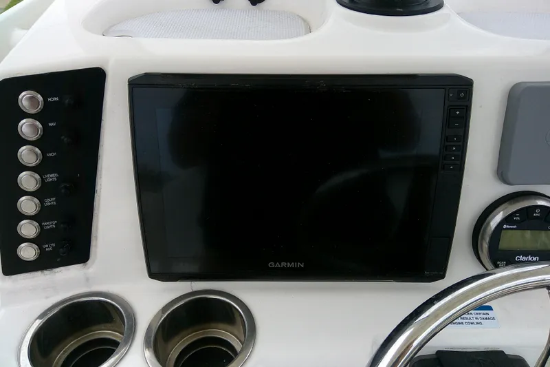 Slide: The Image of 2021 Robalo 246 Cayman dashboard with Garmin display and control panel. - 28
