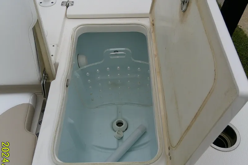Slide: The Image of Open storage compartment on 2021 Robalo 246 Cayman boat, featuring a clean interior. - 32