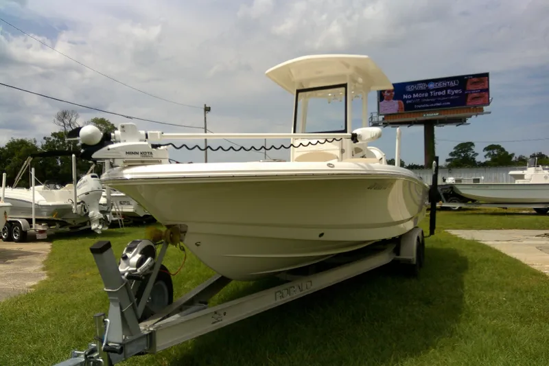 Slide: The Image of 2021 Robalo 246 Cayman boat on trailer, displayed outdoors under cloudy sky. - 37