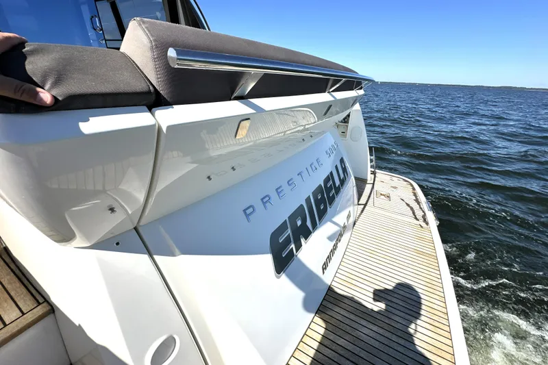 Slide: The Image of 2016 Prestige 500 S yacht on water, rear view with deck and ocean backdrop. - 7