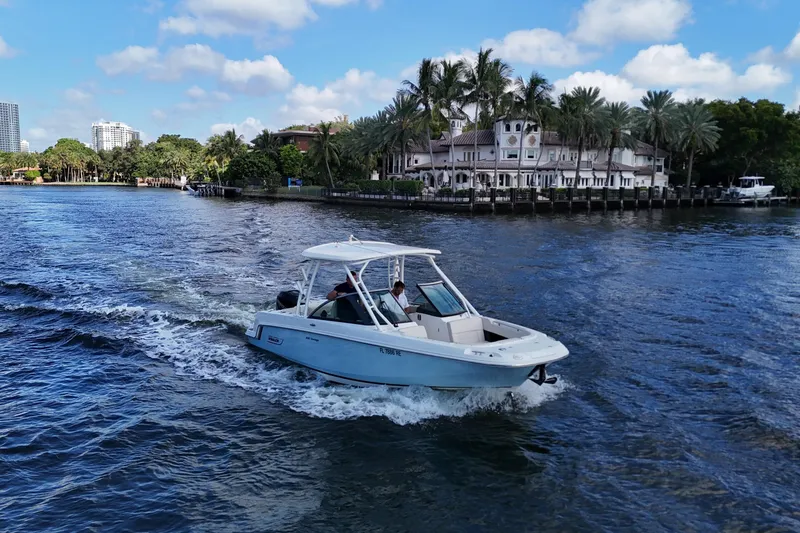 Slide: The Image of 2017 Boston Whaler 230 Vantage cruising on a scenic waterway with palm trees. - 11